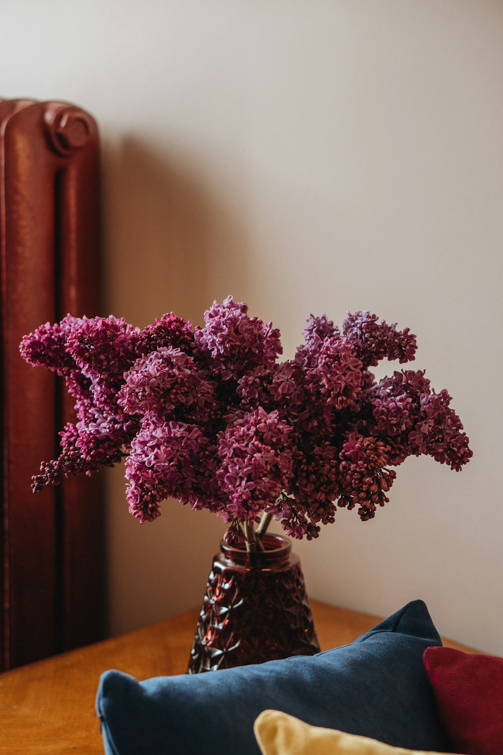 a vase filled with purple flowers on top of a wooden table