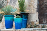 a couple of blue pots sitting on top of a stone wall
