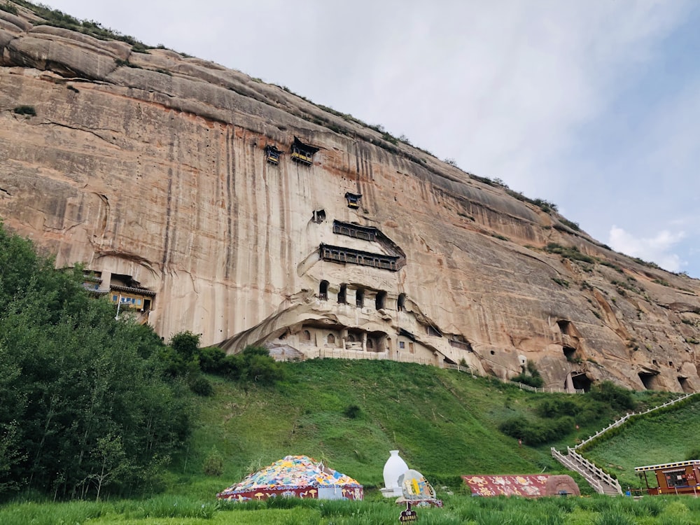 a large cliff with a cave like structure on top of it