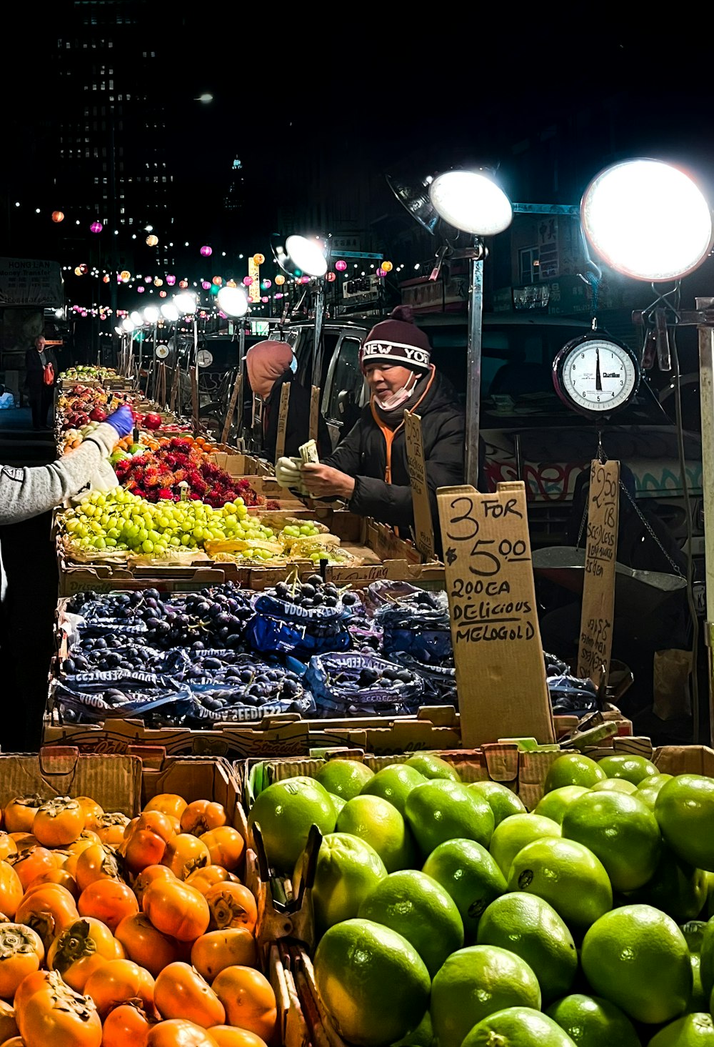 a man standing in front of a fruit stand