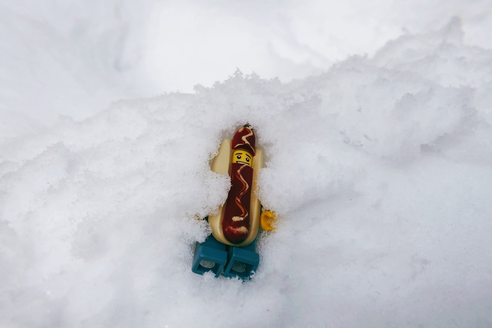 a hot dog on top of a toy car in the snow