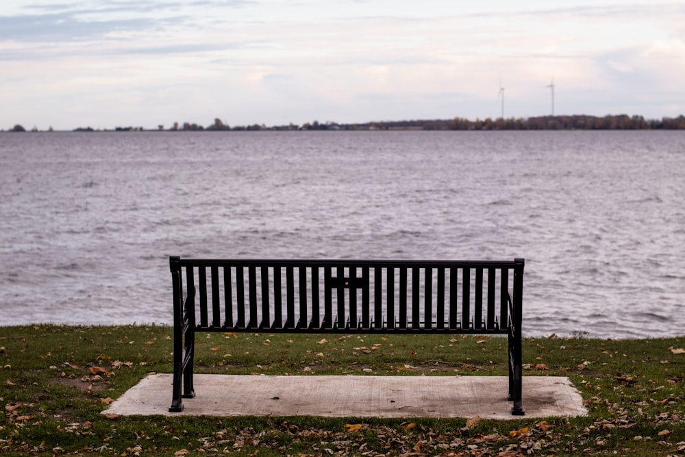 a black bench sitting on top of a grass covered field