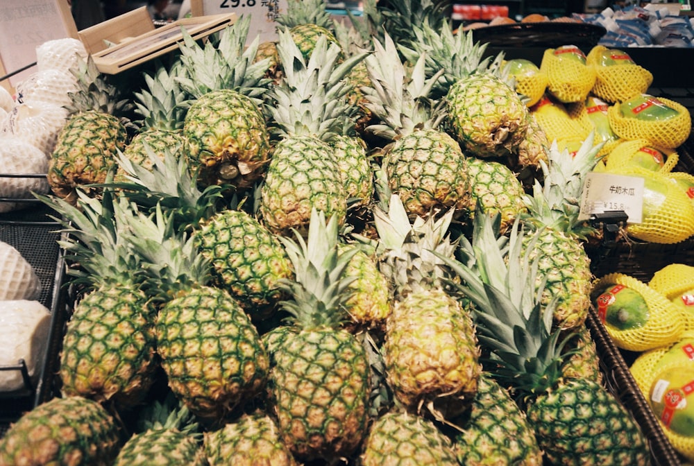 a display of pineapples and other fruits for sale