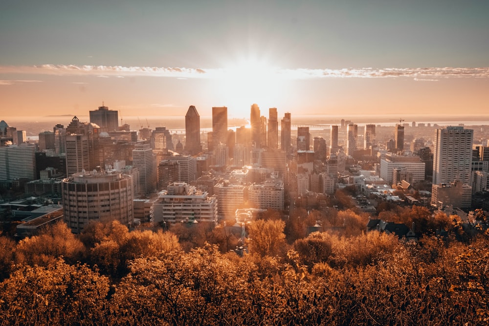 the sun is setting over a city with tall buildings