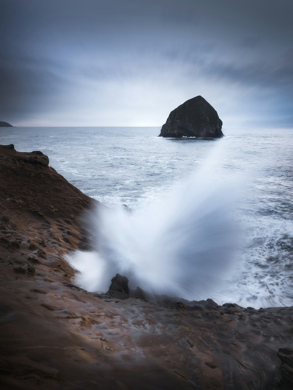 a large rock sticking out of the ocean