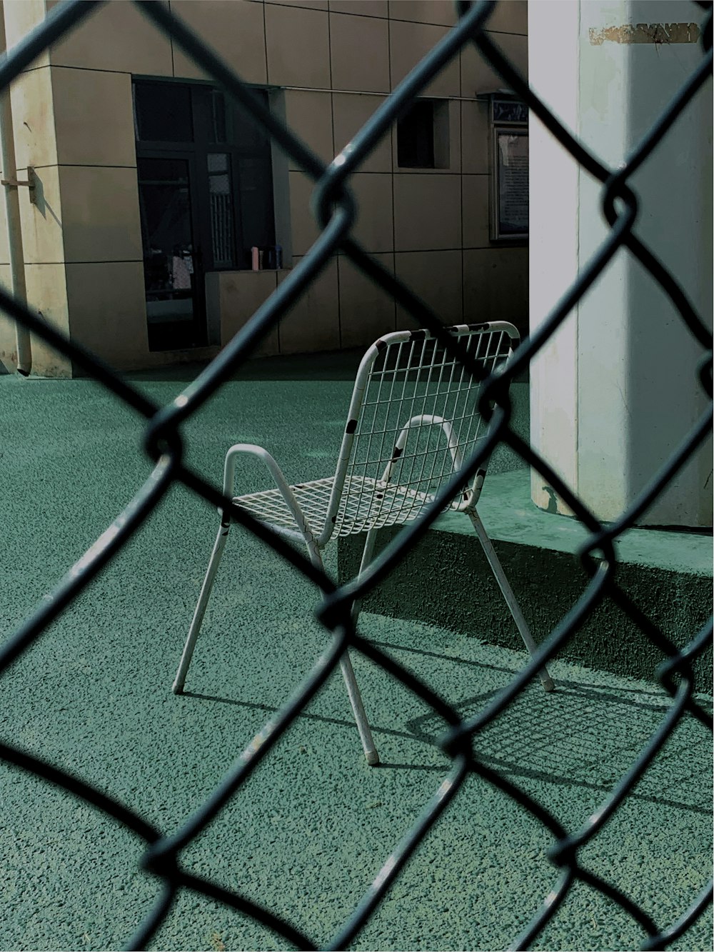 a metal chair sitting on top of a green field