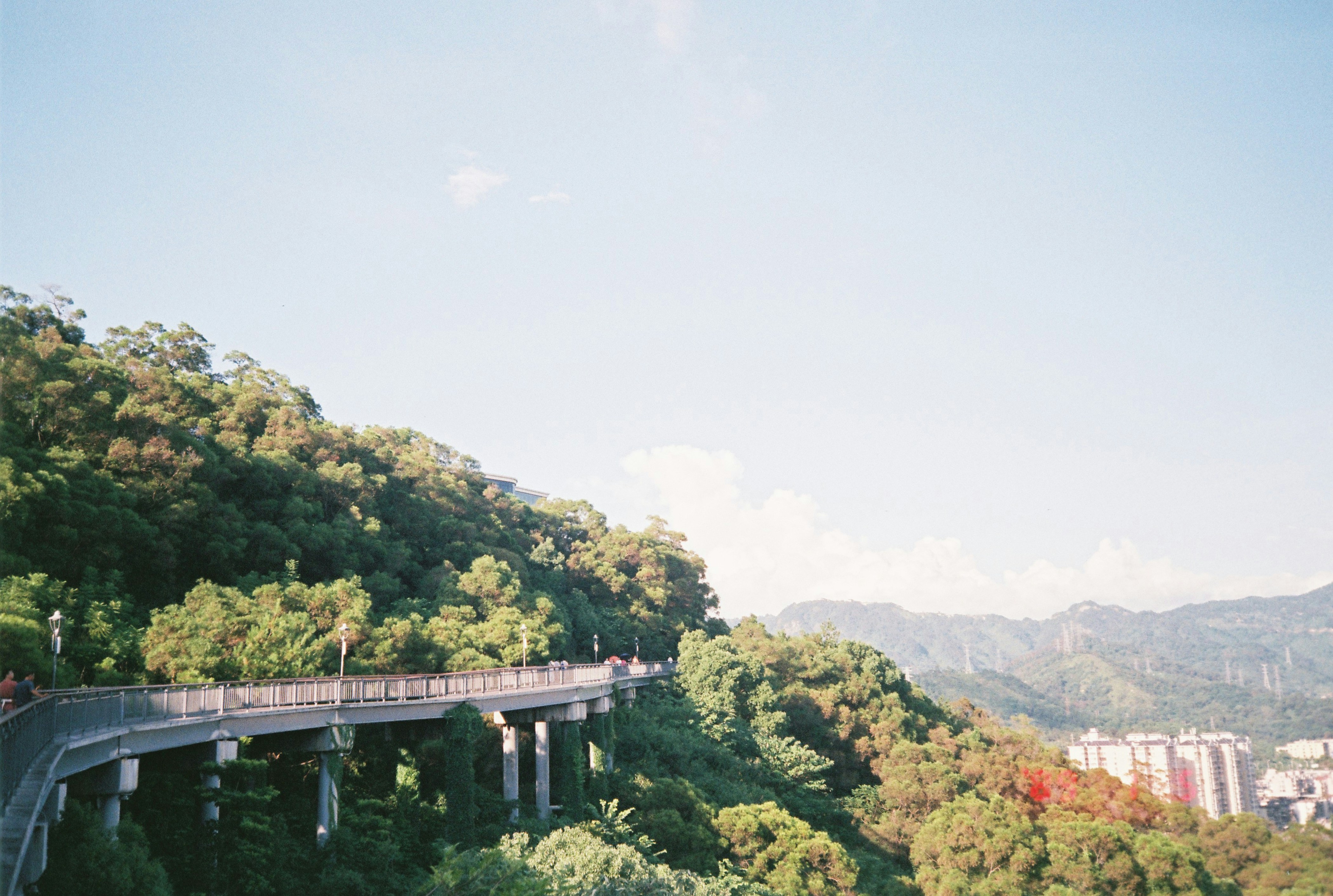 a long bridge over a lush green hillside