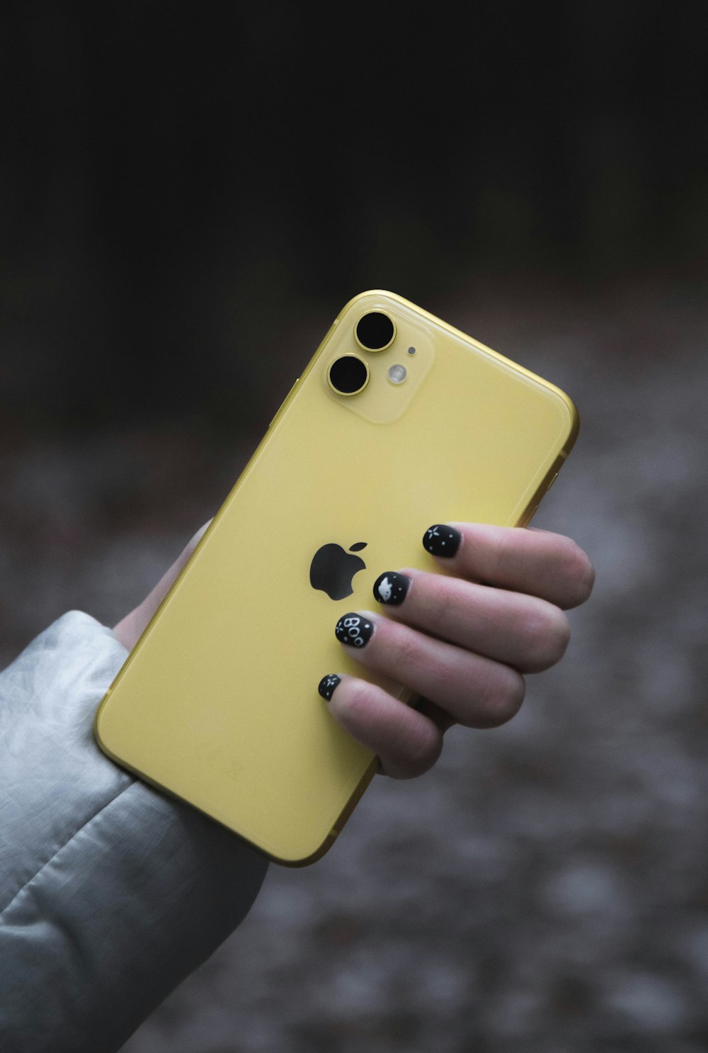 a person holding a yellow cell phone in their hand