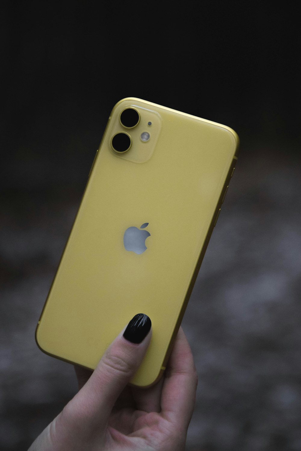 a person holding a yellow iphone in their hand