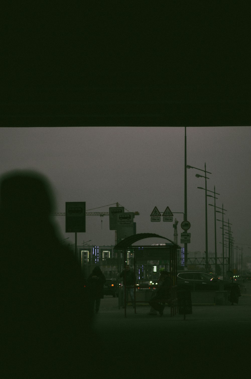 a bus stop at night with a person standing in front of it