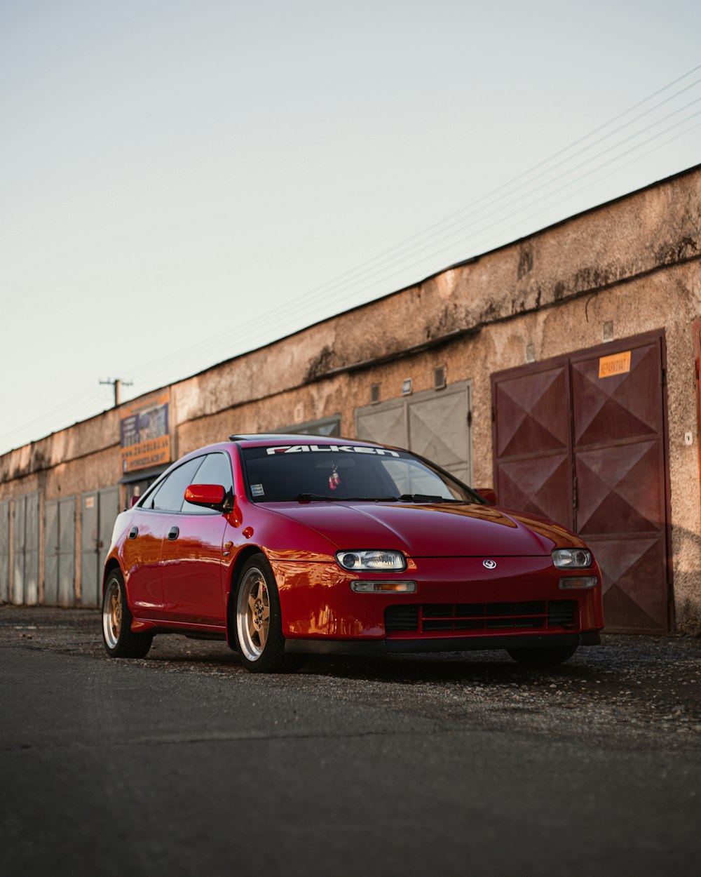 a red car parked in front of a building