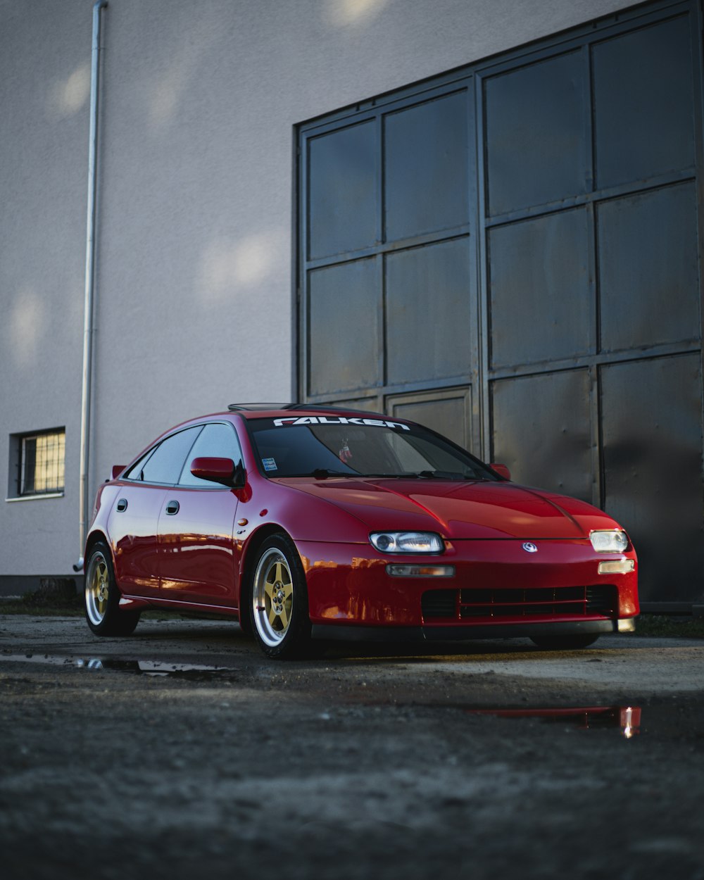 a red car parked in front of a building