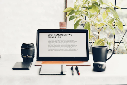 a laptop computer sitting on top of a desk next to a camera