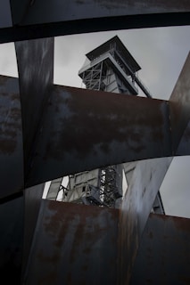 a metal structure with a tower in the background