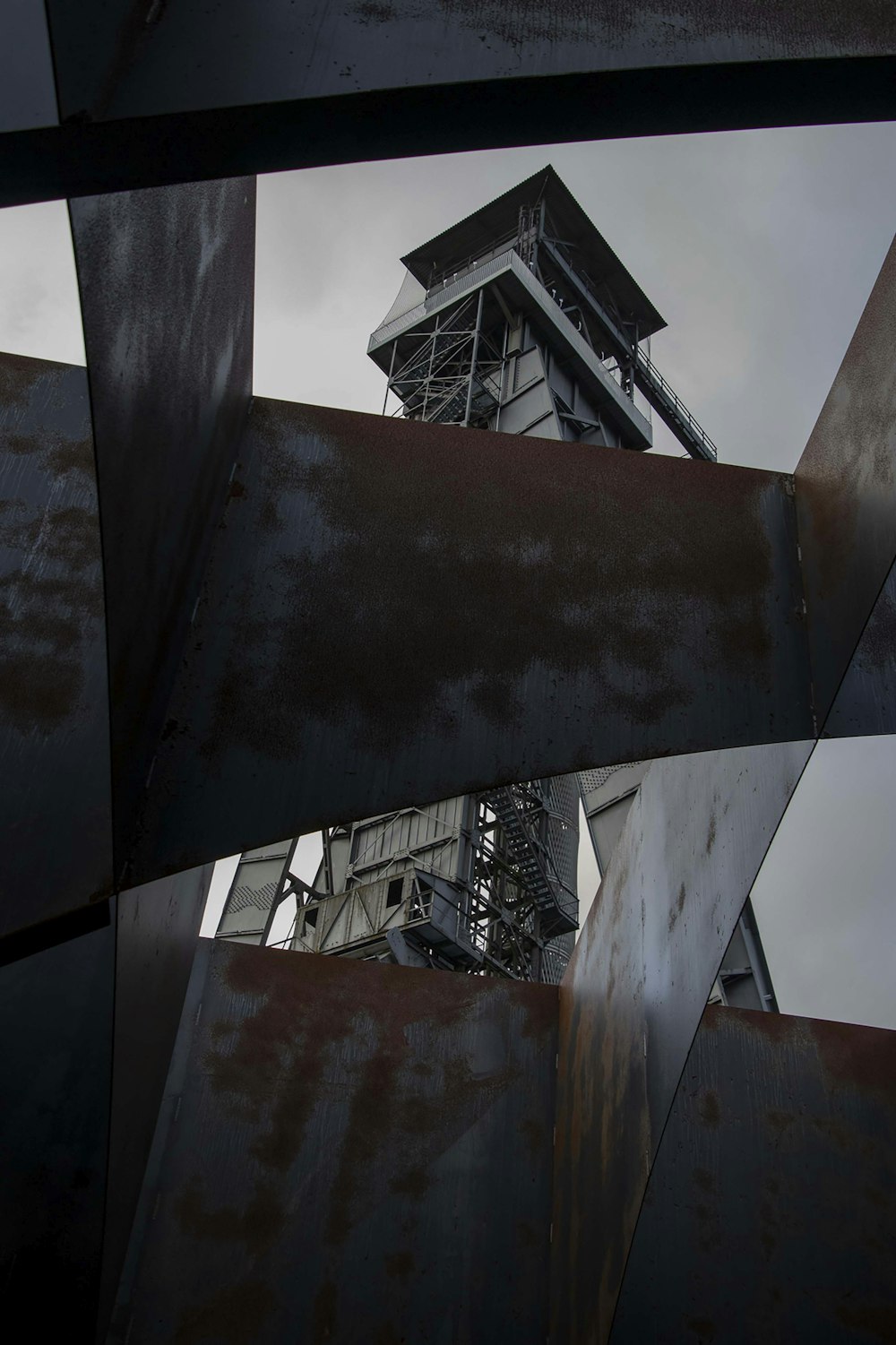 a metal structure with a tower in the background