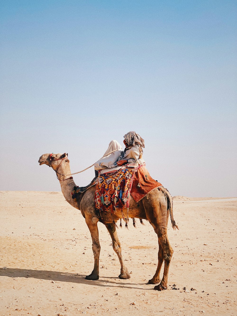 Un uomo che cavalca un cammello nel deserto