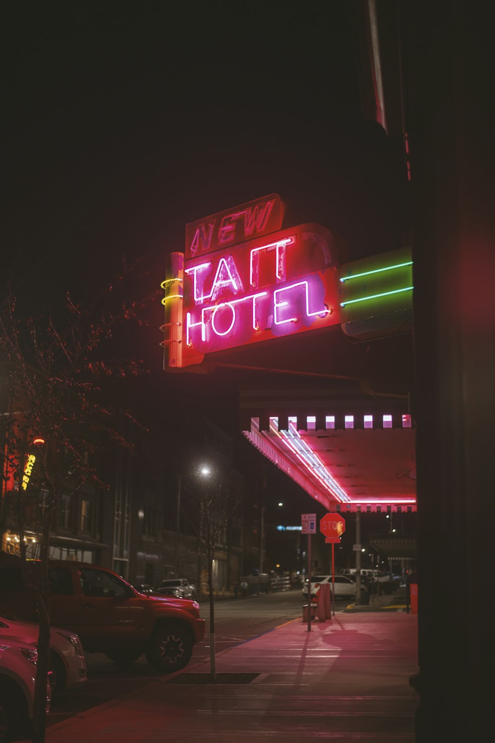 a neon sign for a hotel that is lit up at night