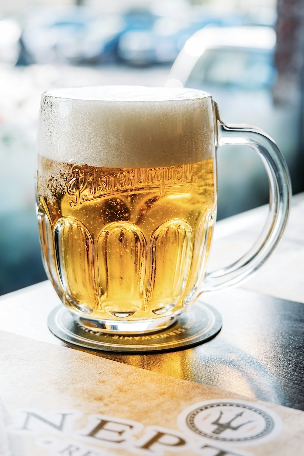 a glass of beer sitting on top of a table