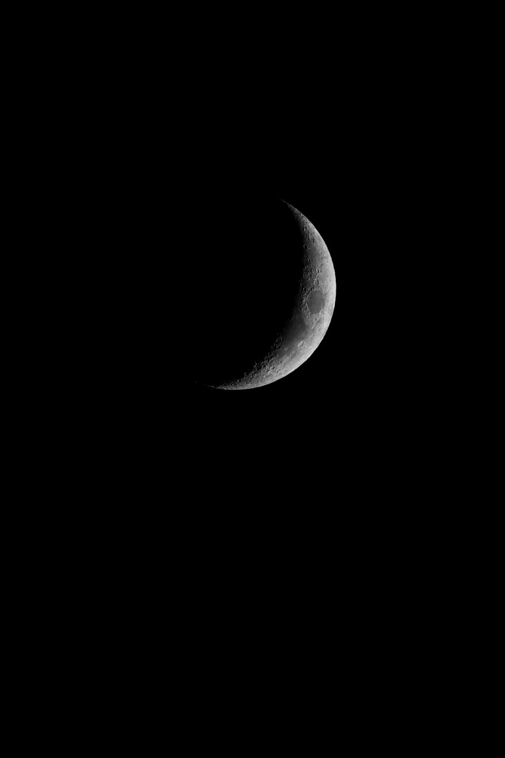 a half moon is seen in the dark sky