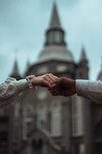 Close-up of hands giving a donation with a church building softly blurred in the background.