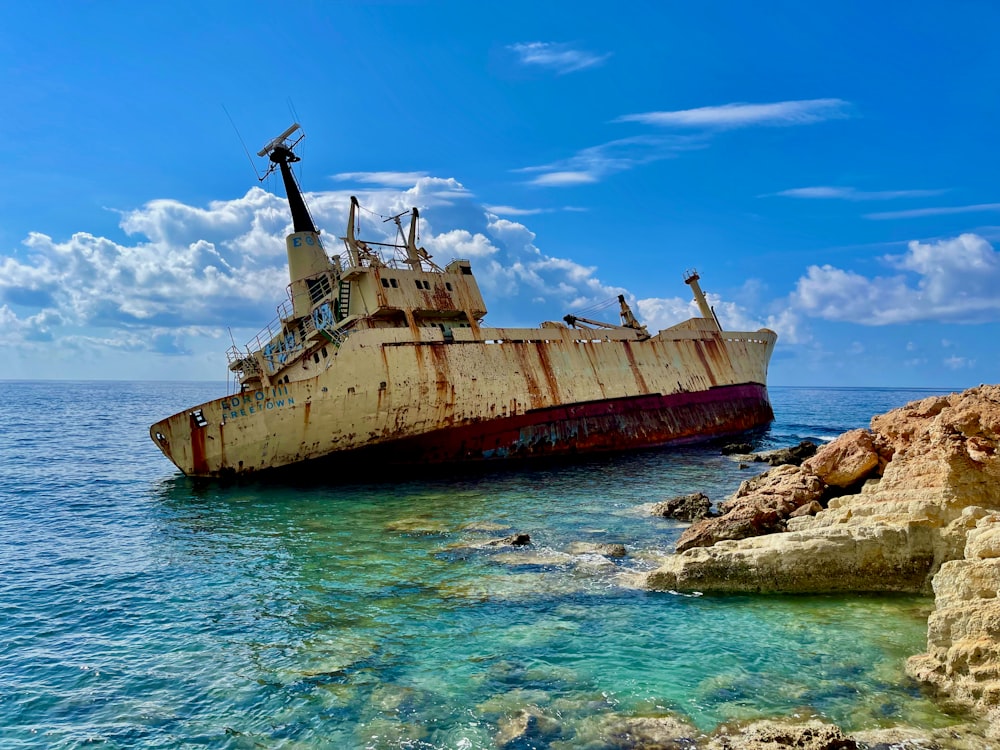 a rusted ship sitting in the middle of the ocean
