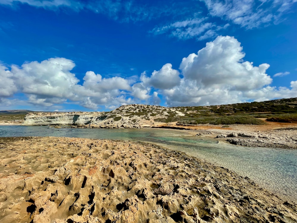 a sandy beach with a body of water in the background