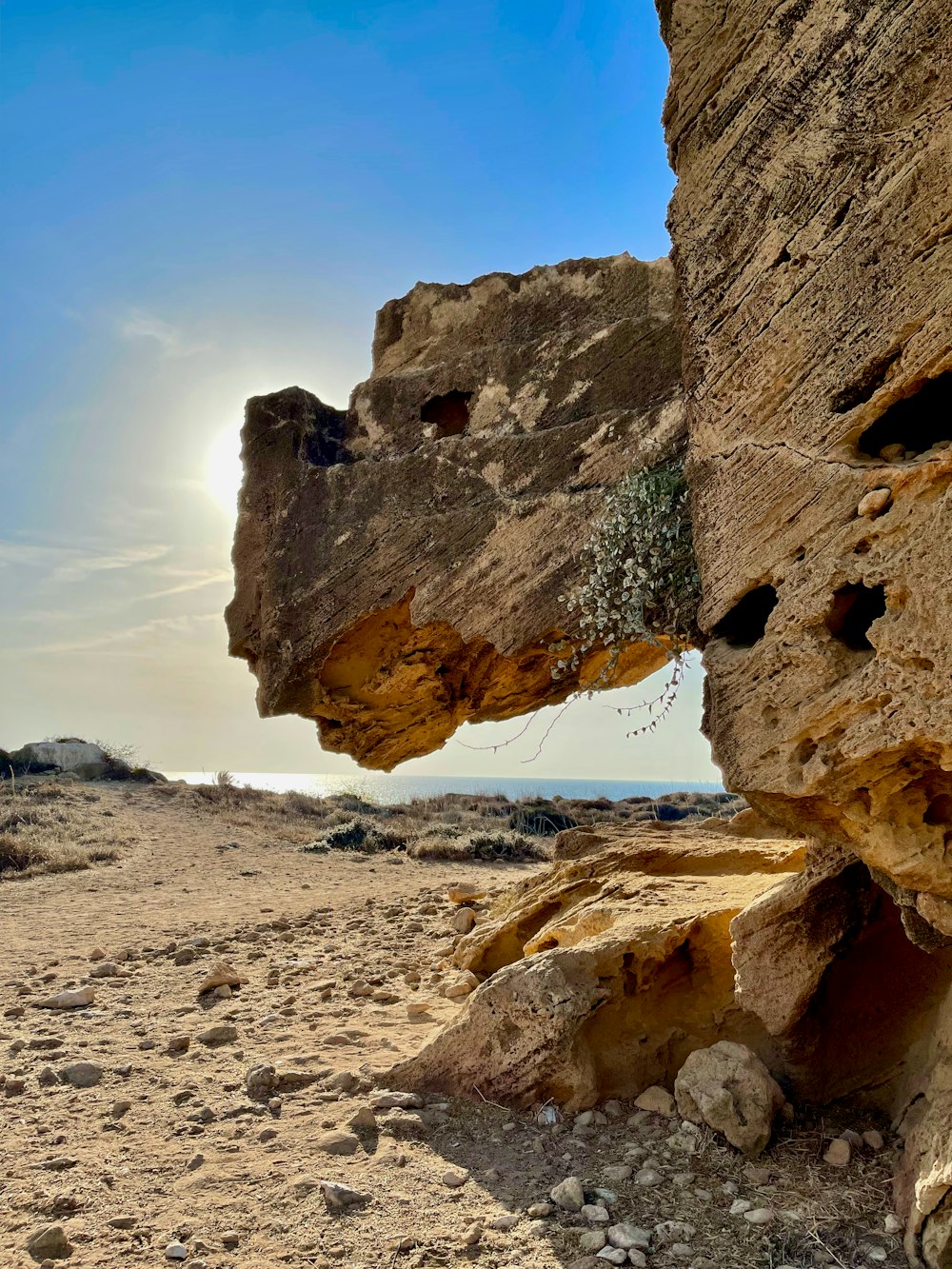 the sun is shining through the rocks on the beach