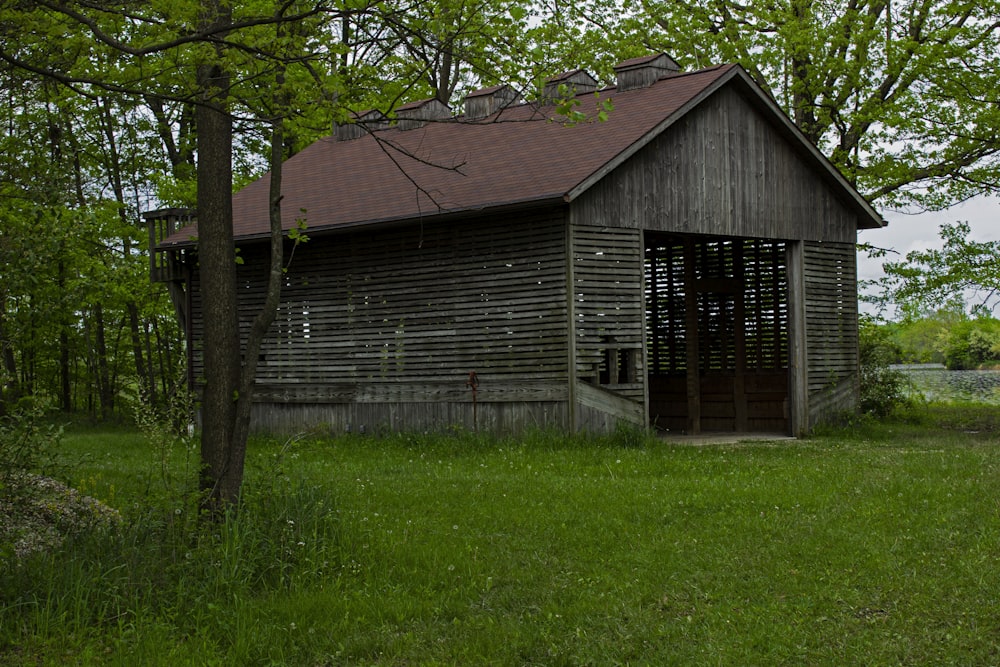 an old wooden building sitting in the middle of a field