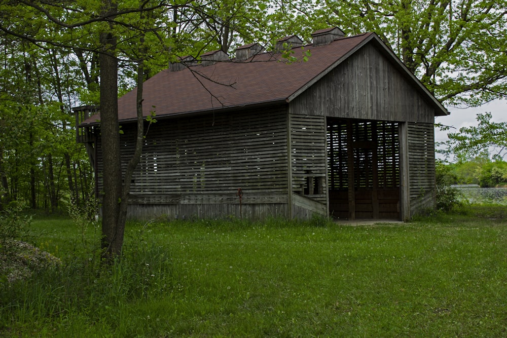 ein altes Holzgebäude mitten auf einem Feld