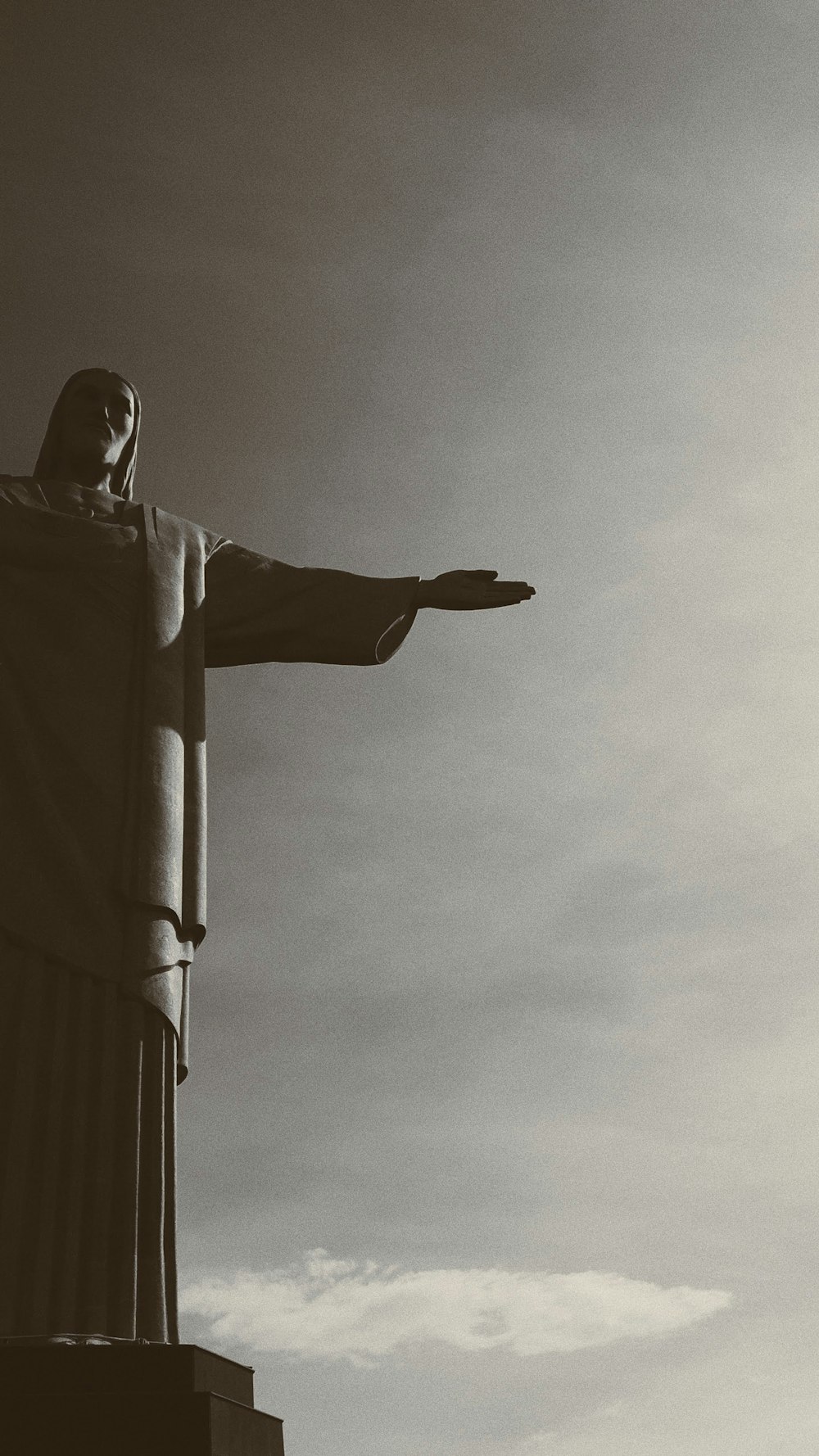 a black and white photo of the statue of christ