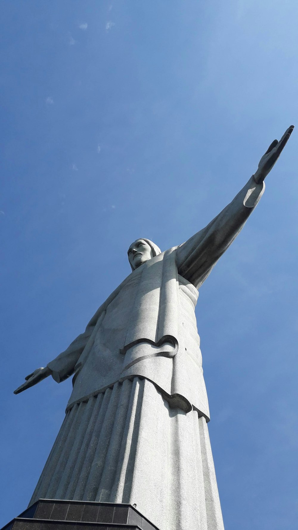 a tall statue of a person with a sky background
