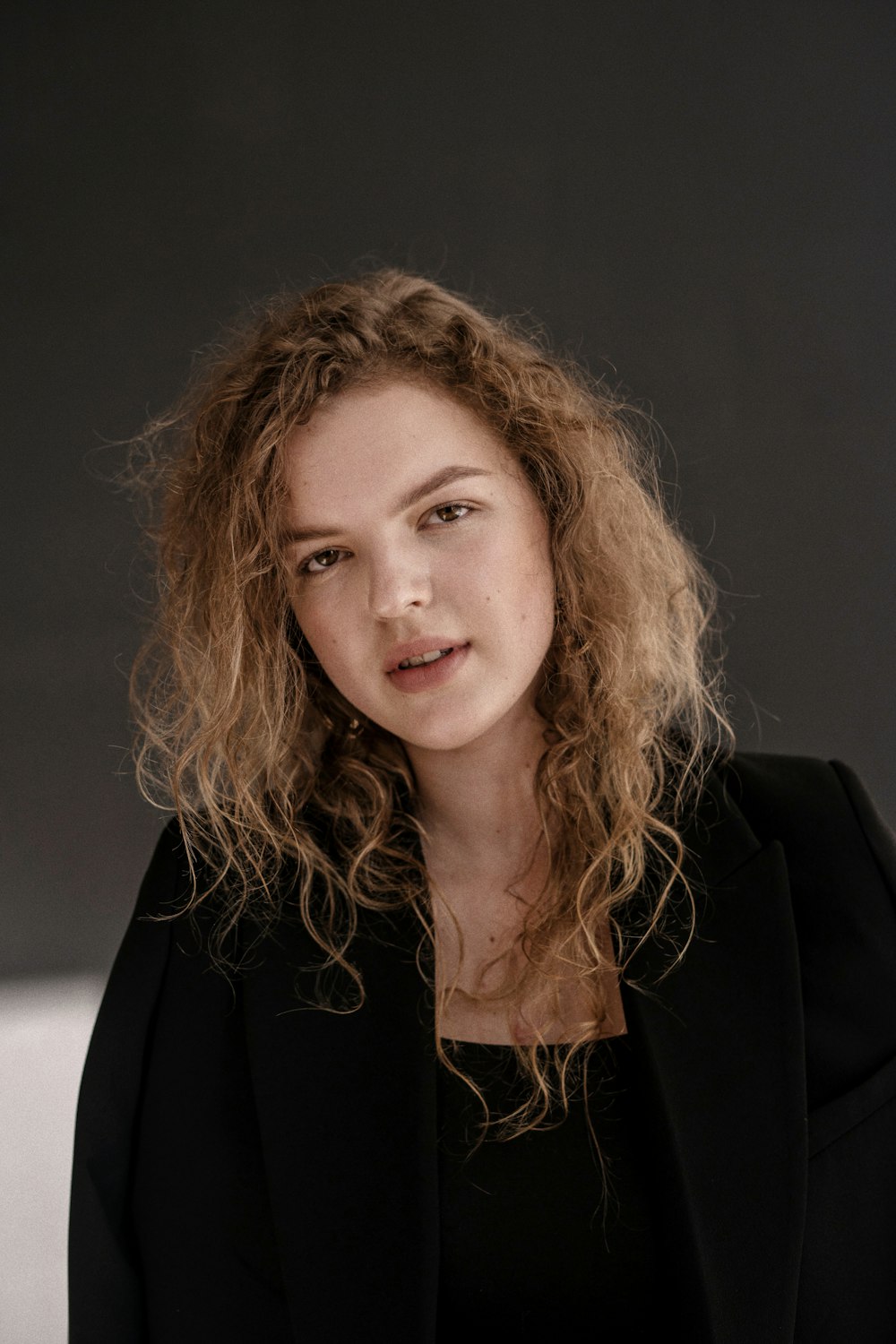 a woman with curly hair and a black jacket