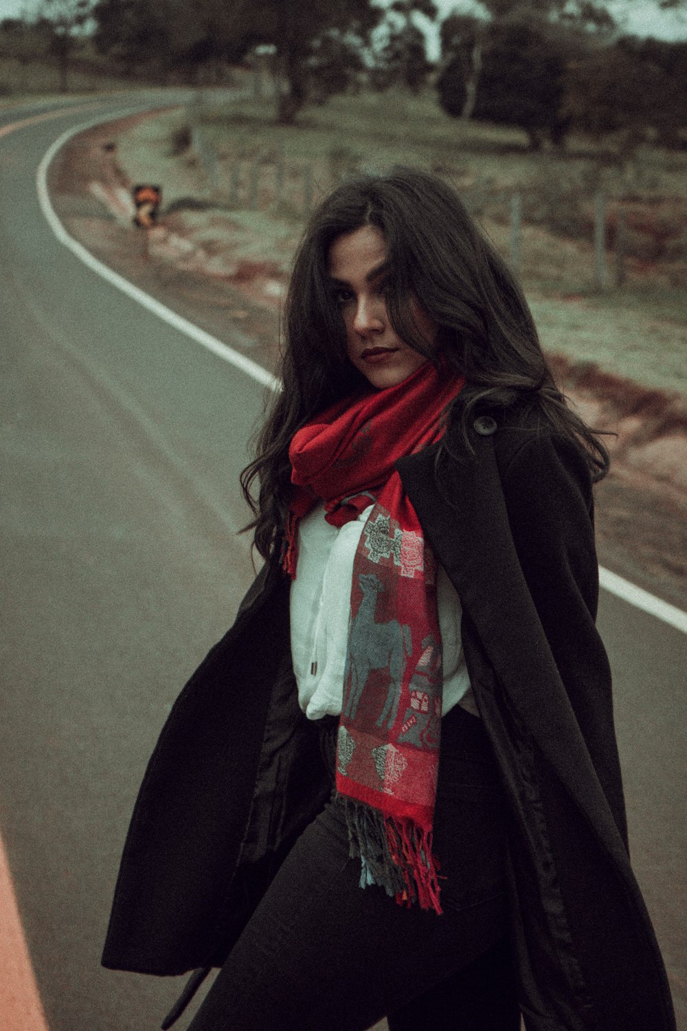 a woman standing on the side of a road