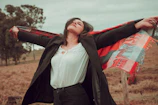 a woman standing in a field with her arms outstretched