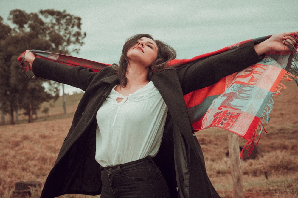 a woman standing in a field with her arms outstretched