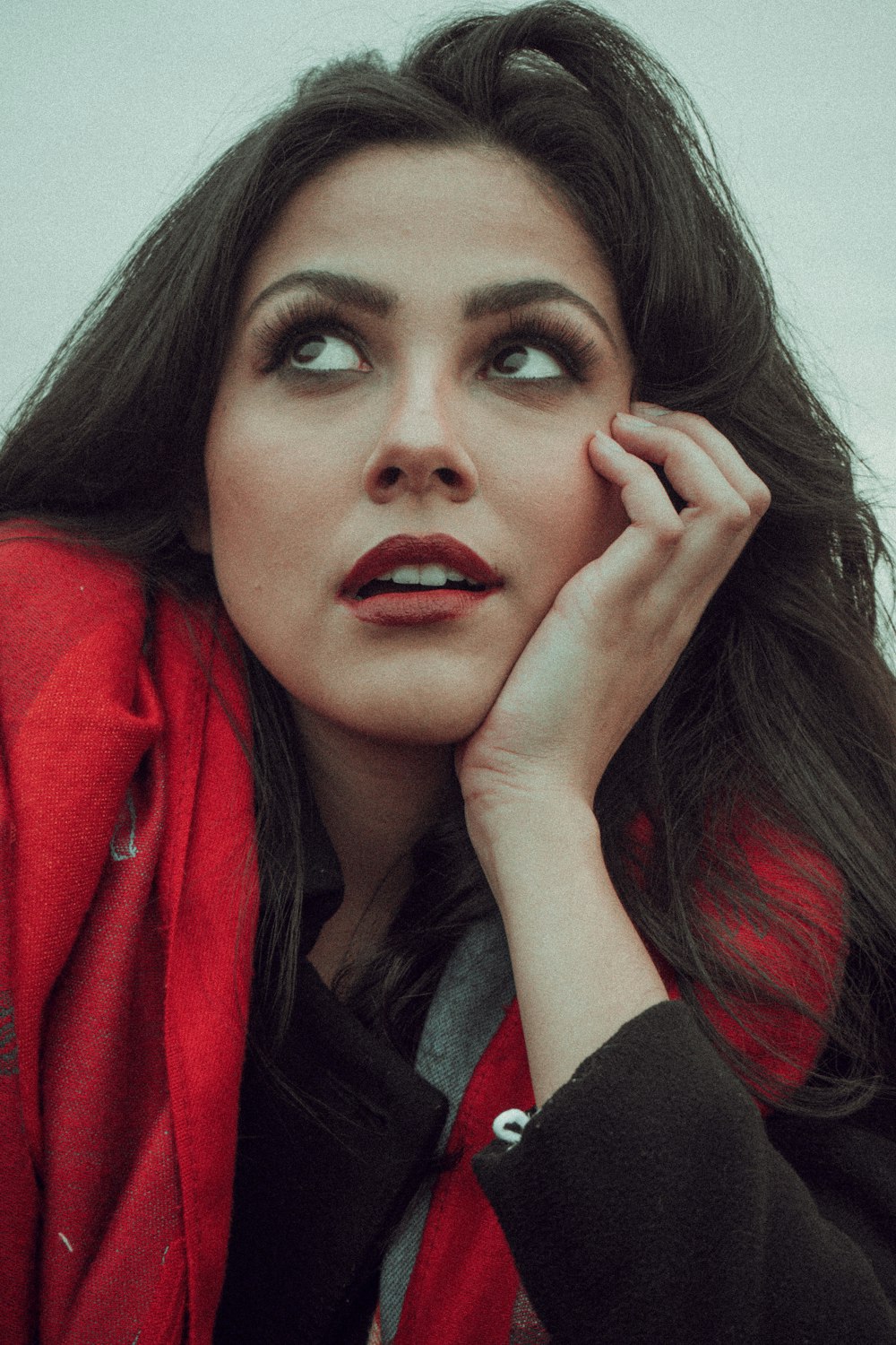 a woman with long dark hair wearing a red jacket
