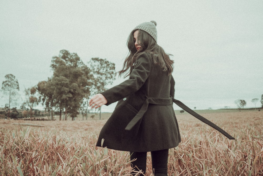 a woman standing in a field of tall grass