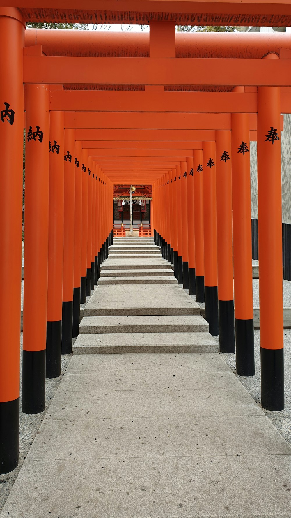 a row of orange and black columns in front of a building
