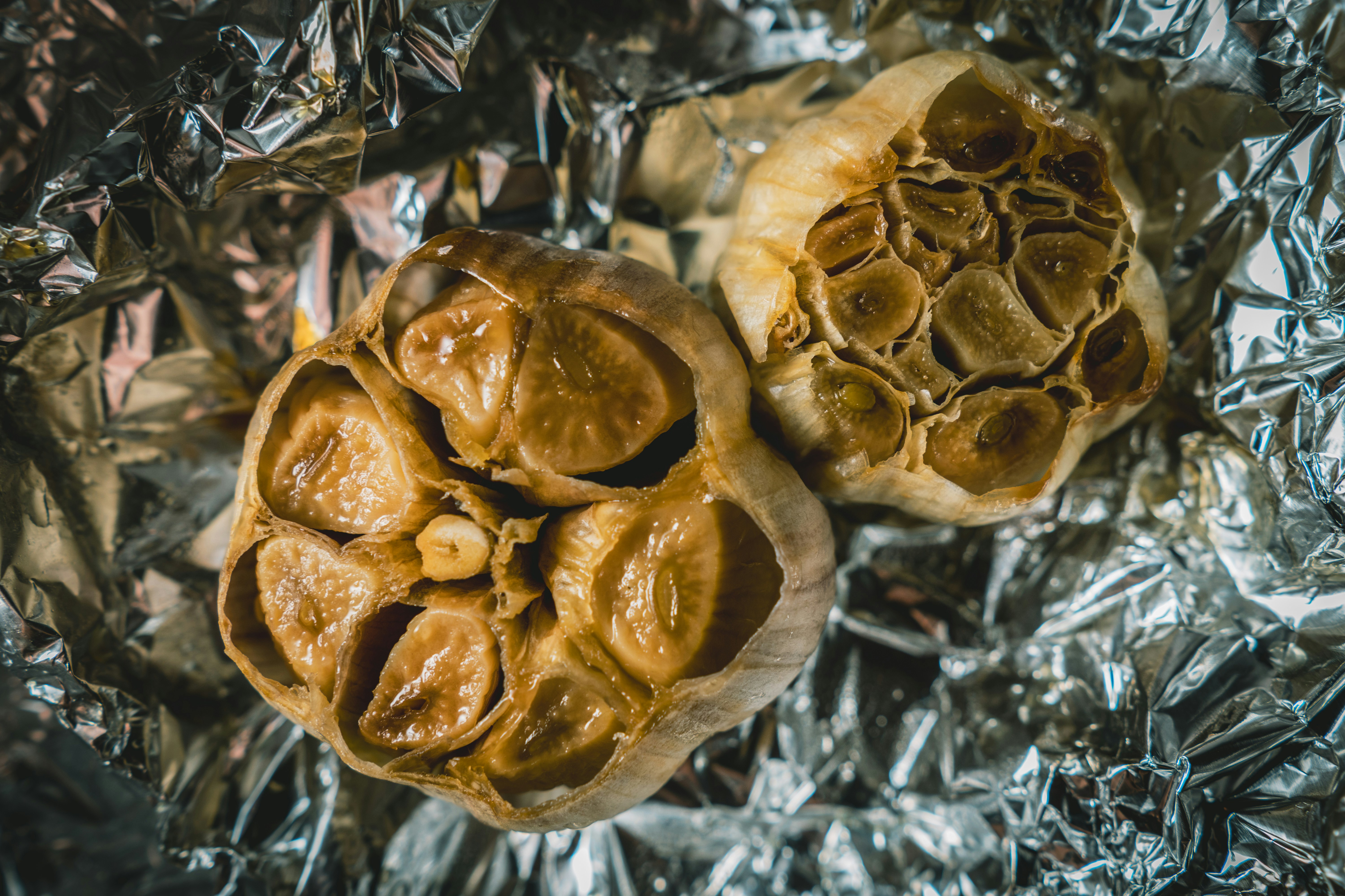 Two crumpled aluminum foil balls on reflective foil surface`

Image 1 is the clear winner. It shows foil balls as the primary, unmistakable subject—two distinct crumpled aluminum balls in sharp focus, exactly what the article needs to demonstrate this steaming technique. Images 2-4 show other kitchen equipment (cooked vegetables on a plate, bread/baked goods, and wooden steamers) that are either unrelated or only tangentially connected to foil balls
