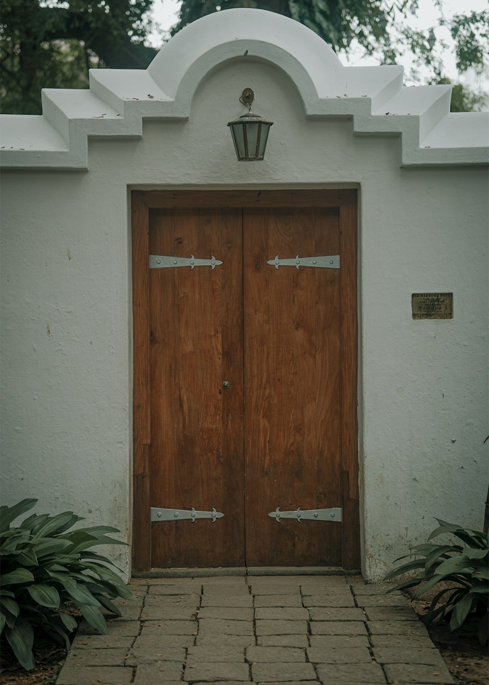 um par de portas de madeira sentadas ao lado de um edifício branco