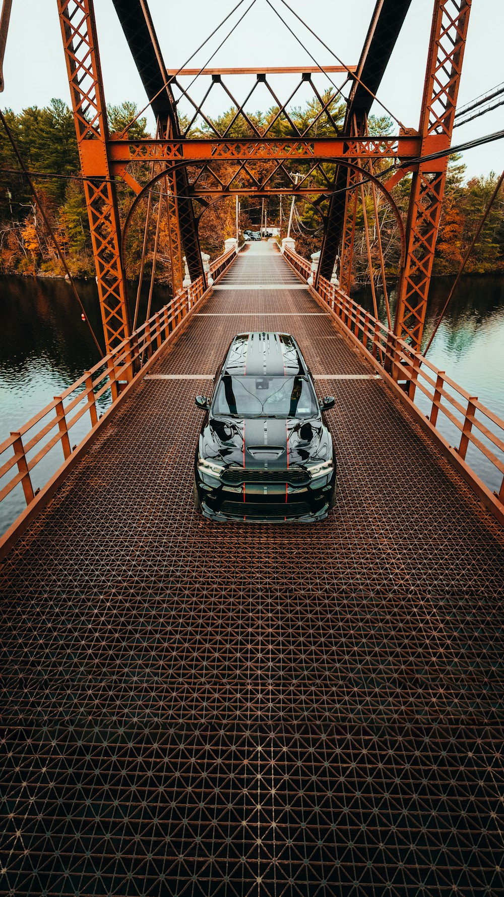 a car is parked on a bridge over water