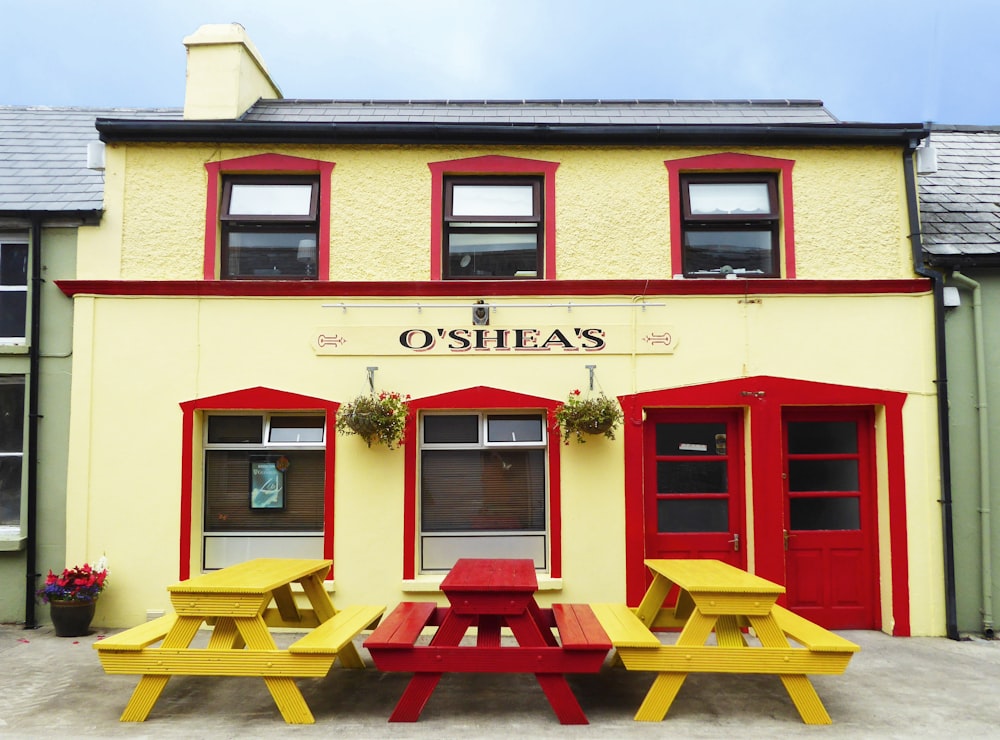 a yellow and red building with a red and yellow picnic table in front of it