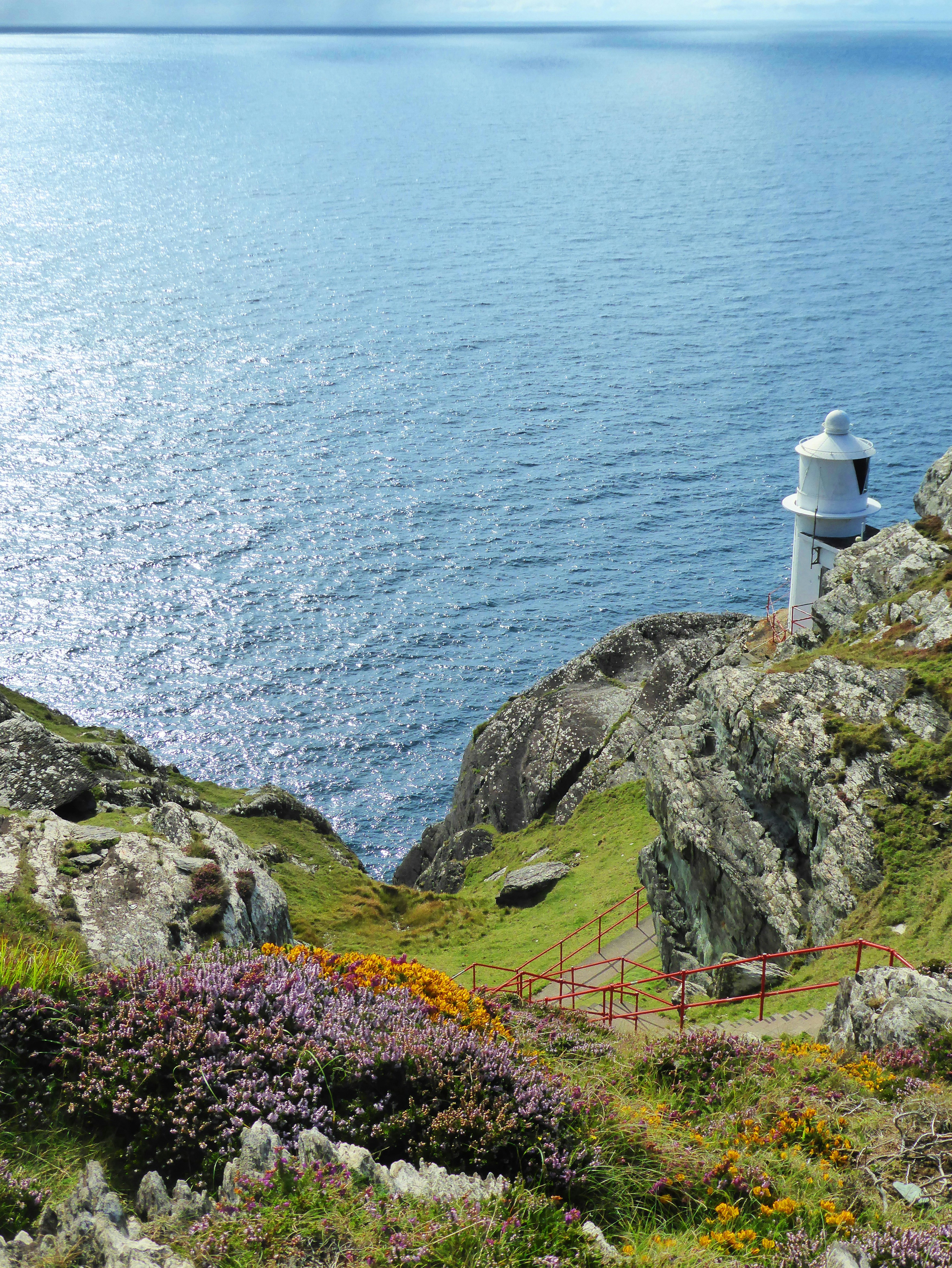 a lighthouse on a cliff overlooking the ocean