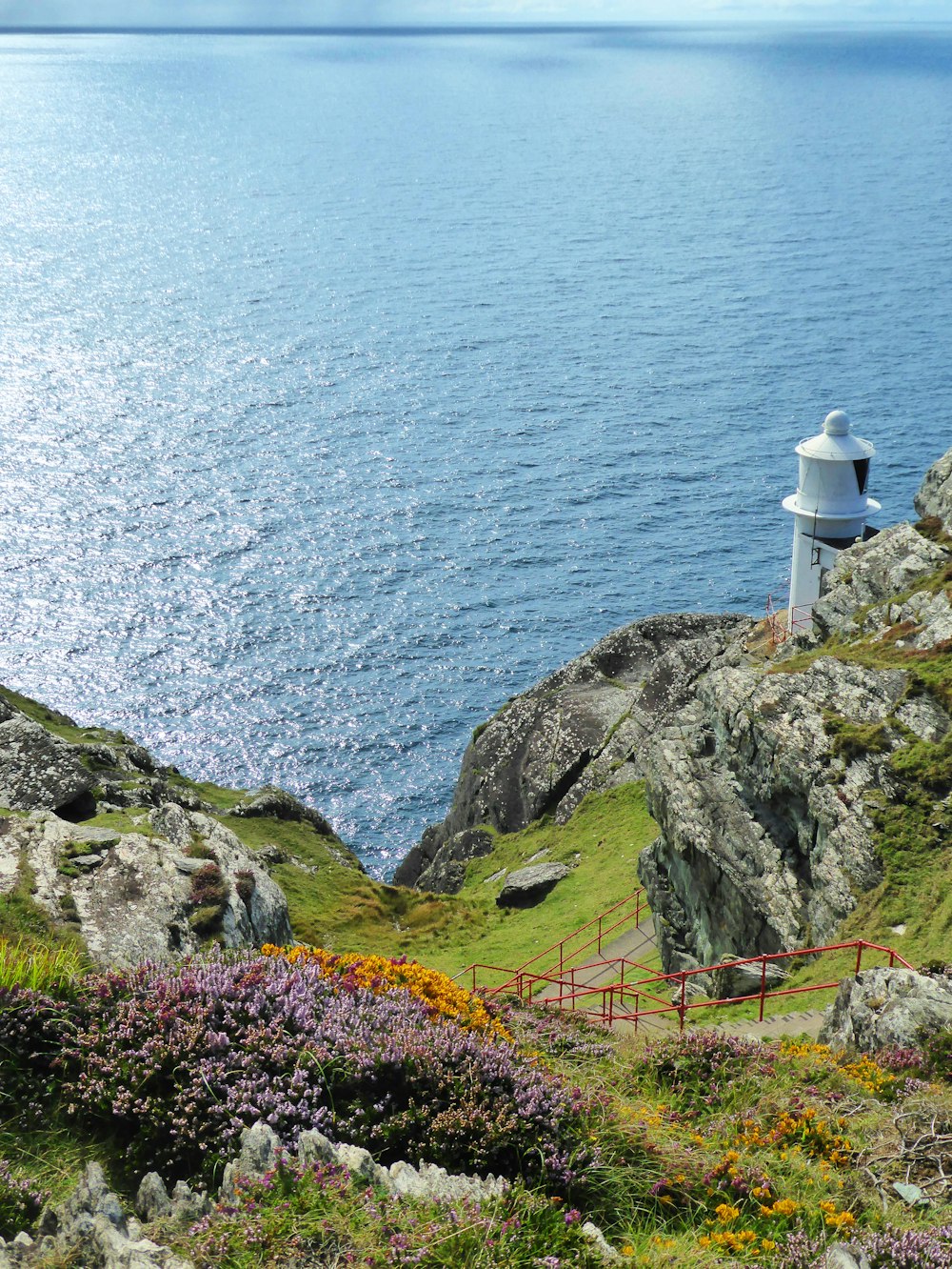 a lighthouse on a cliff overlooking the ocean