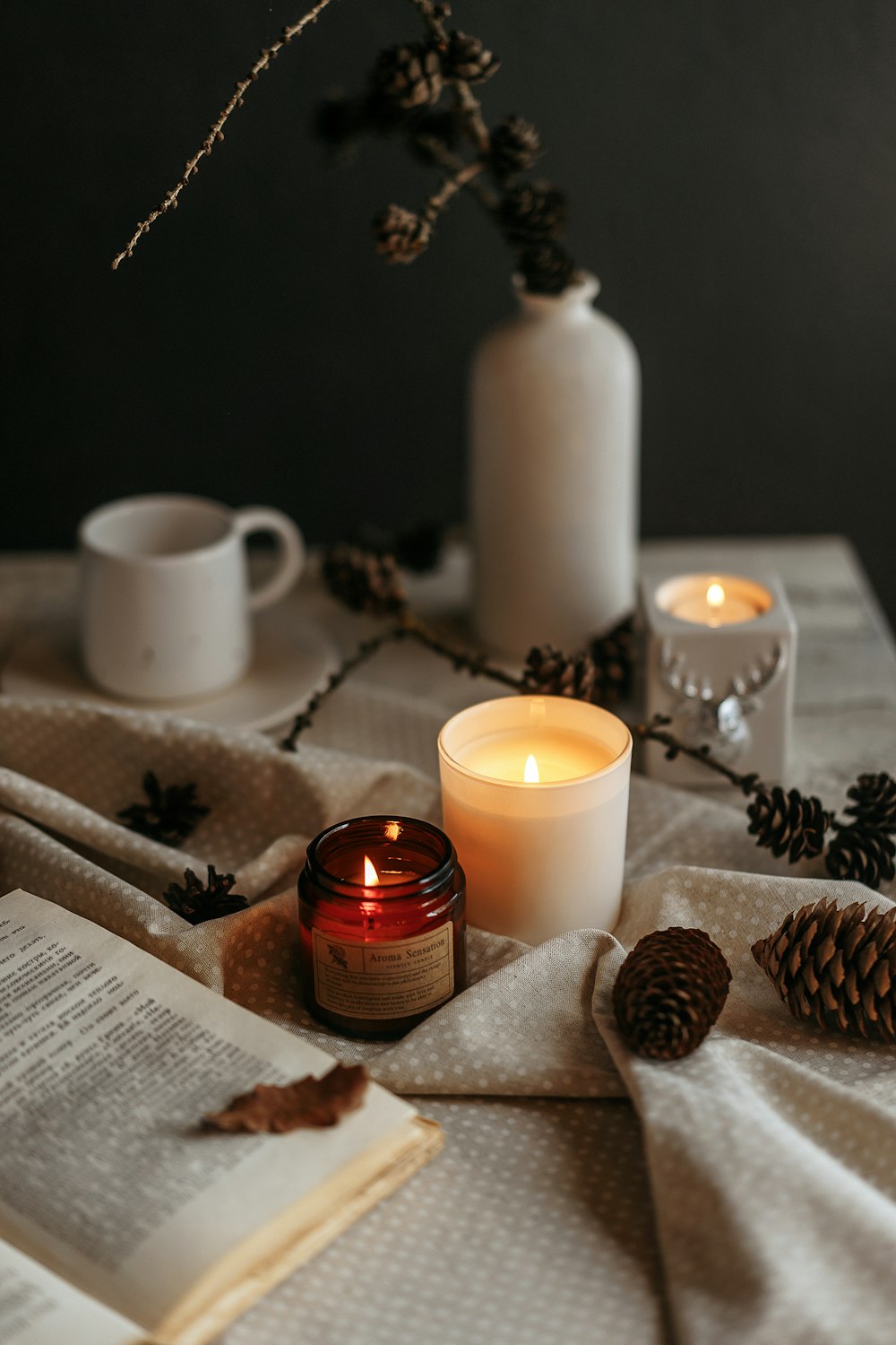 a table topped with a candle and a book