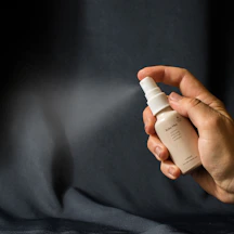 a person holding a bottle of lotion in their hand