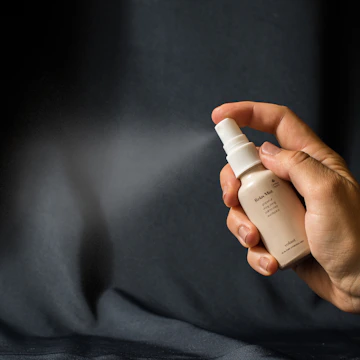 a person holding a bottle of lotion in their hand