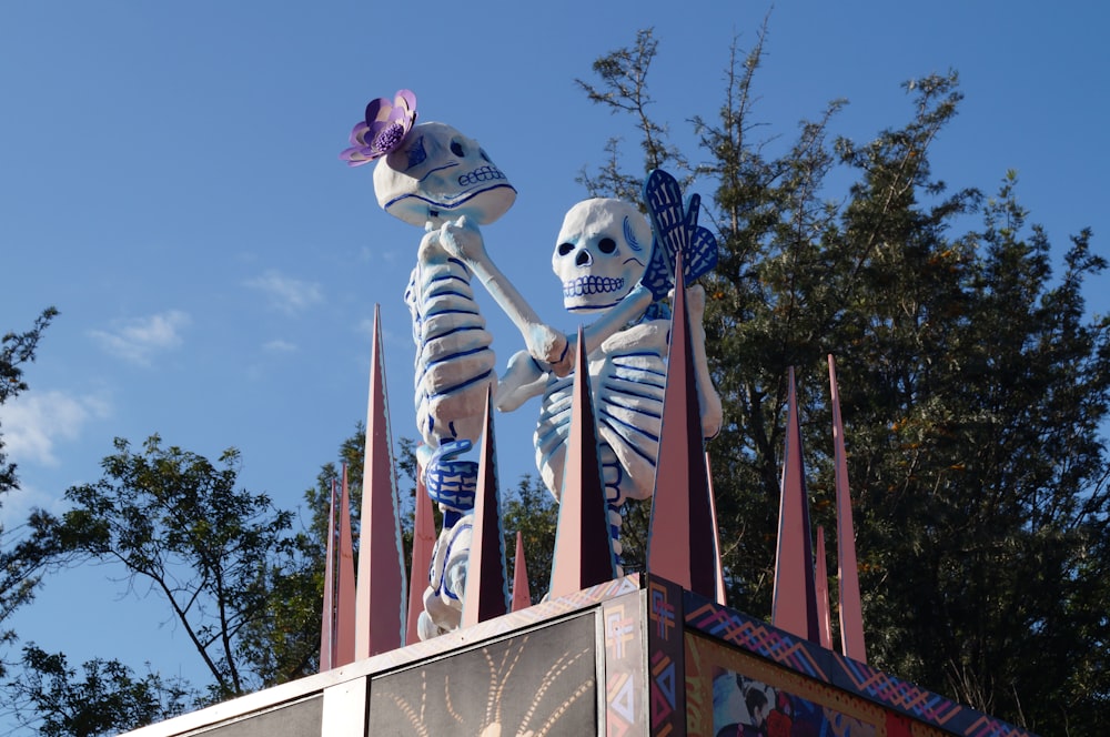 um par de esqueletos em pé em cima de um passeio de carnaval