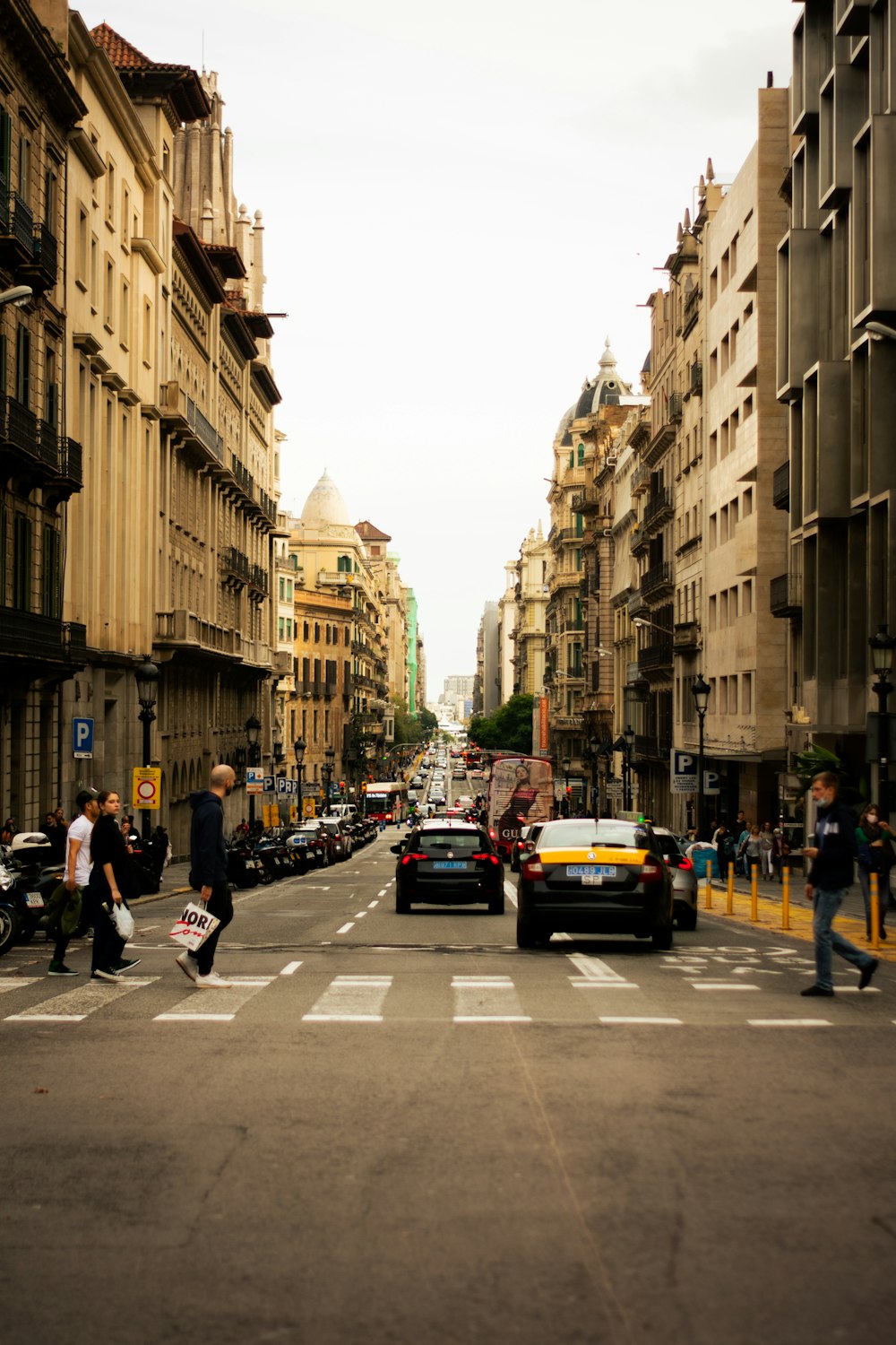 a city street filled with lots of traffic next to tall buildings