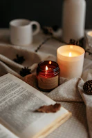 A cozy arrangement of everyday essentials like candles, mugs, and books on a rustic table.